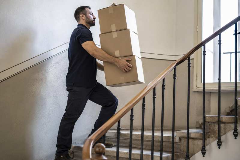 Déménageur portant des cartons dans un escalier