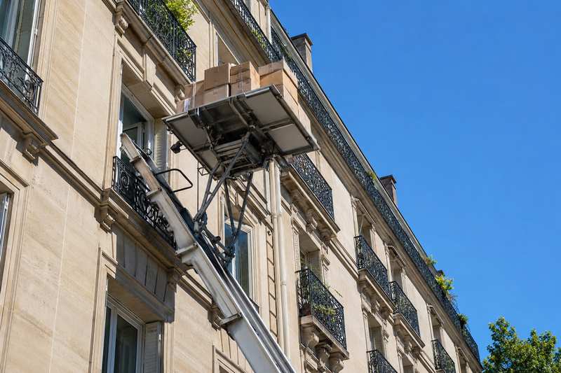 Monte-meuble le long de la façade d’un immeuble